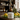 Lemon balm jar with lemons and herbs on a wooden surface, shelves with bottles in the background