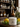 Lemon balm jar with lemons and herbs on a wooden surface, shelves with bottles in the background